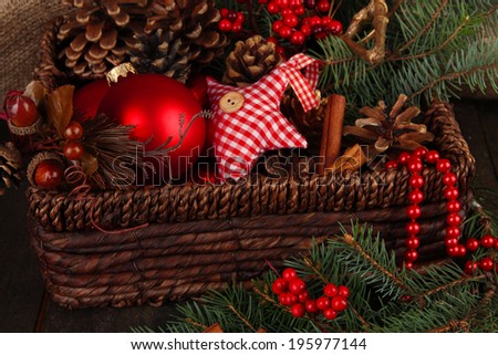Christmas decorations in basket and spruce branches on table close up