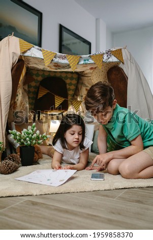 Brothers playing in a diy tent in the living room. Camping at home concept