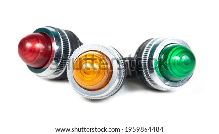Red, yellow and green pilot lamps are used in the work of the control system. Three light bulbs on white background.