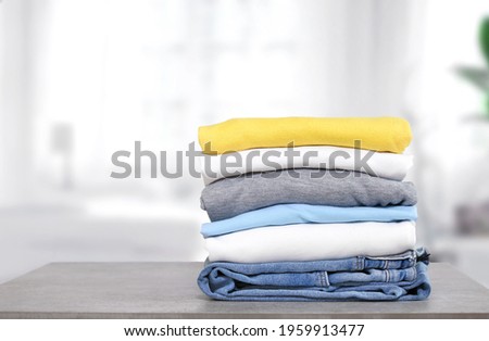 Stack of cotton colorful clothes on table indoors.Stacked apparel.Folded clean clothing.Household. Royalty-Free Stock Photo #1959913477