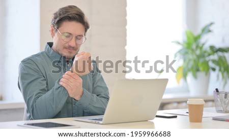 Middle Aged Man with Laptop having Wrist Pain