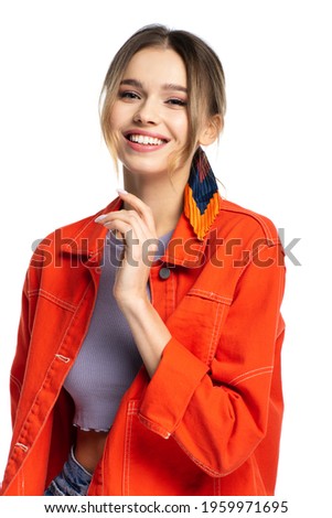 positive young woman in crop top and orange shirt isolated on white