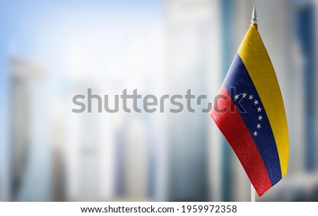 A small flag of Venezuela on the background of a blurred background