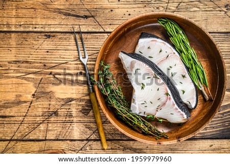 Raw Blue Shark steaks in a wooden plate. wooden background. Top view. Copy space