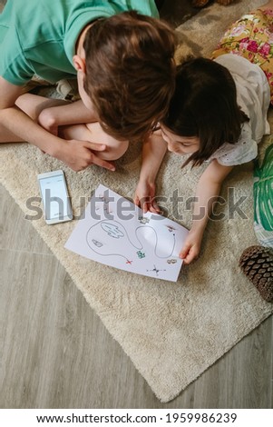 Top view of unrecognizable kids playing treasure hunt at home on the carpet Royalty-Free Stock Photo #1959986239