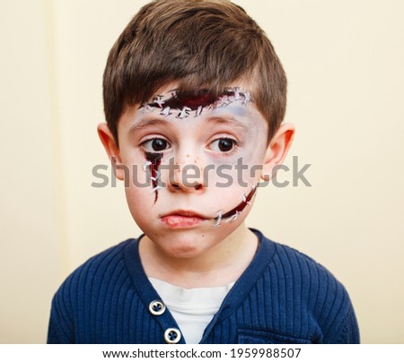 little cute child with facepaint on birthday party, zombie Apocalypse facepainting, halloween preparing concept, lifestyle people