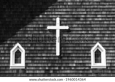 Old Catholic Church with Cedar Shake Shingles, white cross and windows in black and white.