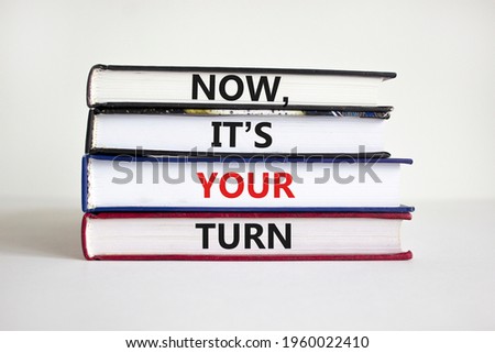 It is your turn symbol. Books with words 'now, it is your turn' on beautiful white background. Business, motivational, your turn concept. Copy space.