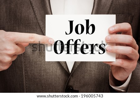 "Job Offers" written on a signboard in businessman's hands