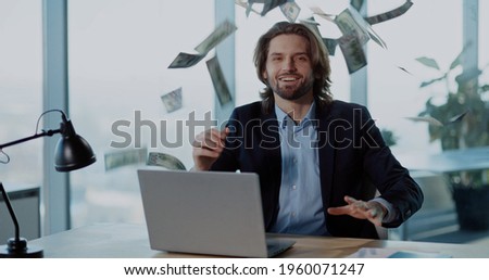 Indoor Portrait of Successful Office Worker Young Businessman throwing Money Rain of Dollars Smiling Celebrating Payday Salary.