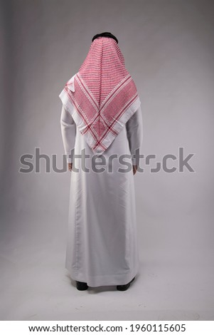 Arab middle eastern Saudi man in traditional formal thobe and Shimagh, on white isolated background, with different expressions, hand gestures and poses, studio lighting ready for cutout and editing Royalty-Free Stock Photo #1960115605