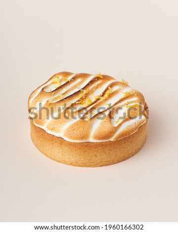 Lemon meringue tart on beige background. 