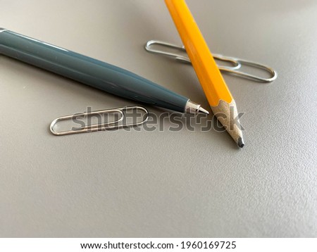 Automatic green ballpoint pen and pencil with paper clips for writing on your desktop office desk. Business work.