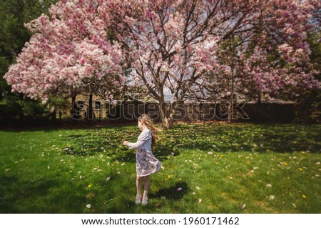 Child playing by a magnolia tree