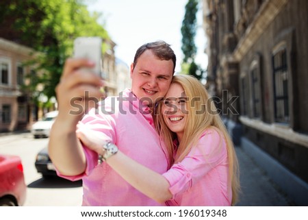 Happy couple taking photo of themselves or making selfie by smartphone