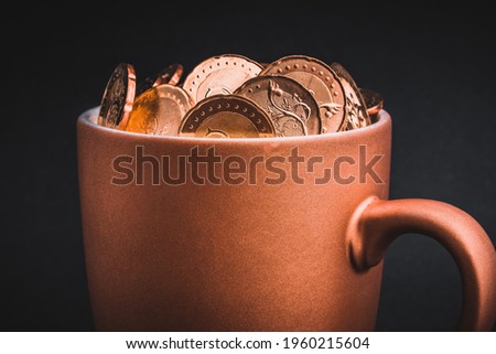 Golden Coins in cups on black background. Tax, Finance, Profit and Investment Concept