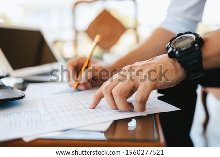 Administrator businessman making report, calculating balance. Business analyzing income charts, graphs and data on the table.