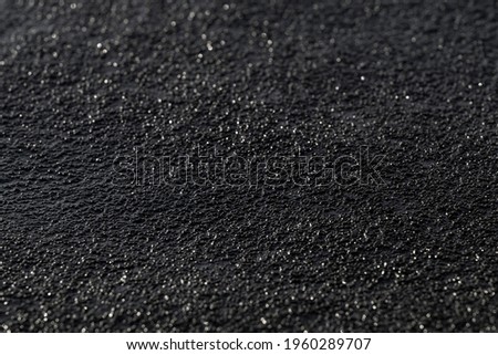 Wet bitumen texture. Black glitter background. Dark surface with blurred glare. Royalty-Free Stock Photo #1960289707