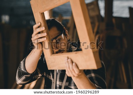 The carpenters man high experienced wood worker making furniture. master of woodcraft male looking at workpiece closeup with fine detail. Royalty-Free Stock Photo #1960296289