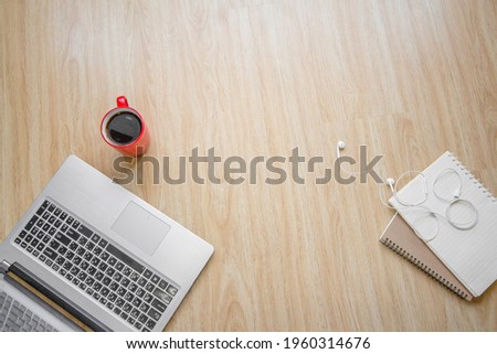 Wooden work desk top view  with computer, cup of coffee a headphones and notebook .with copy space, flat lay