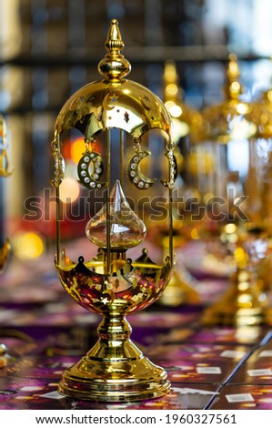 Table lamp with golden decoration. Mosques dome and crescent moon, symbol islamic religion and free space background well for text arabic present. Blurred background, selective focus