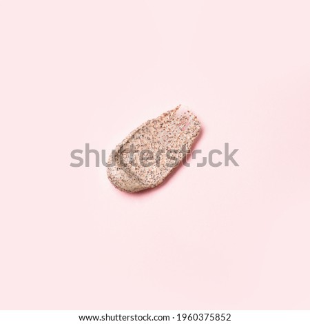 Smeared drop of brown scrub with coffee and apricot on pink background, beauty abstract concept, copy space, flyer, coupon for beauty salon