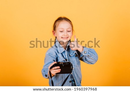 Child with camera. Little girl photographing in studio