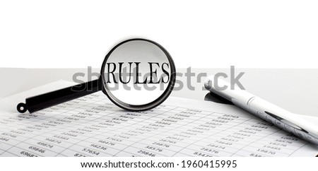 Magnifying glass with text RULES on the chart background with pen