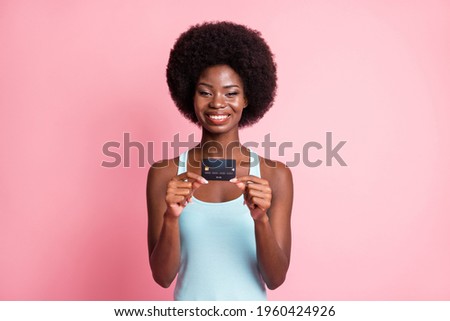Photo of imprressed nice brunette curly lady hold card wear blue top isolated on pastel pink color background