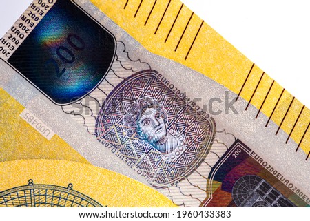 Holograms and security images on a fragment of a European banknote on a white background