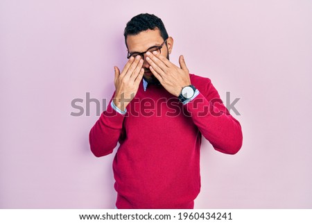 Hispanic man with beard wearing business shirt and glasses rubbing eyes for fatigue and headache, sleepy and tired expression. vision problem 