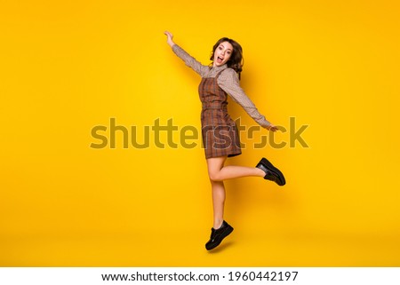 Full size profile photo of optimistic funny brunette lady jump yell wear shirt dress sneakers isolated on vivid yellow background