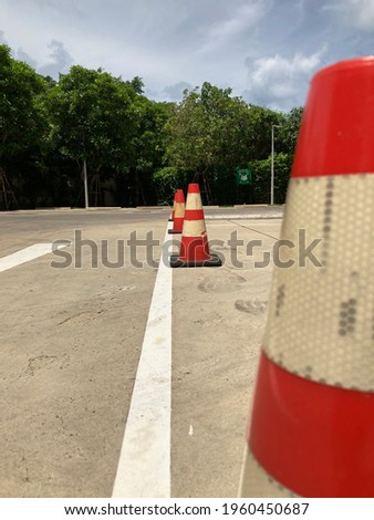 Red traffic cones are on the road.