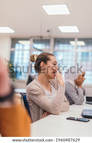 Portrait of a tired businesswoman yawning while having a business meeting in the office. Royalty-Free Stock Photo #1960487629