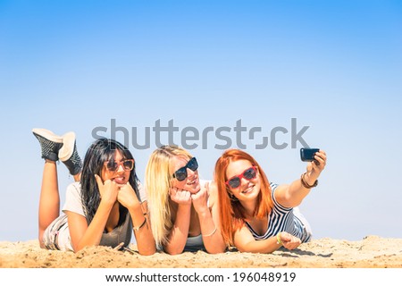 Group of girlfriends taking a selfie at the beach - Concept of friendship and fun in the summer with new trends and technology - Best friends enjoying the moment with modern smartphone