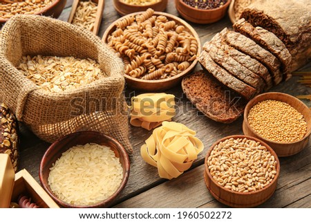 Different cereals, raw pasta and bread on wooden background, closeup Royalty-Free Stock Photo #1960502272
