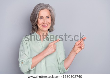 Photo of happy good mood lovely beautiful mature woman advertising product option isolated on grey color background
