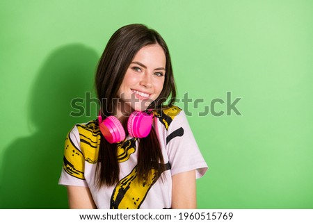 Photo of charming young positive young woman smile wear pink headphones isolated on green color background
