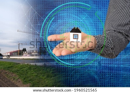 close-up of architect's, realtor's hand holding a model building, rows of identical new houses, elite cottage community, new housing construction concept, mortgage, home insurance