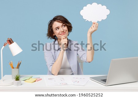 Young successful employee business woman in shirt sit work at white office desk with pc laptop empty blank Say cloud speech bubble promotional content prop up chin isolated on blue background studio Royalty-Free Stock Photo #1960525252