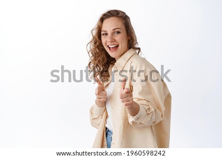 You got this. Smiling blond girl cheer up, praising or choosing you, pointing fingers at camera and looking happy, standing over white background