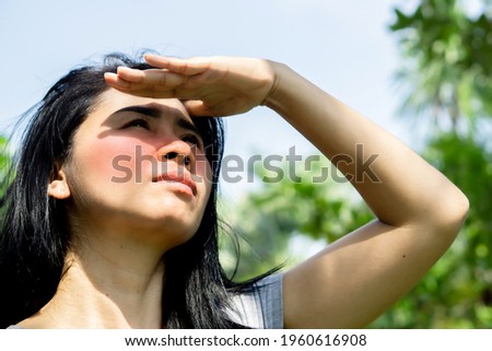 Asian woman having problem sunburn redness on face skin hand cover her face to protect ultraviolet from sunlight standing outdoors under sunny  Royalty-Free Stock Photo #1960616908