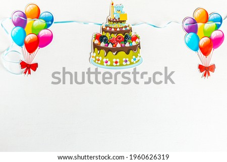 colorful paper balloon and birthday cake on white background
