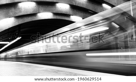 Monochrome long exposure photography of a subway train in motion in a station