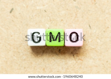 Color alphabet letter block in word GMO (abbreviation of Genetically Modified Organisms) on wood background