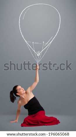 Beautiful young woman holding balloon drawing