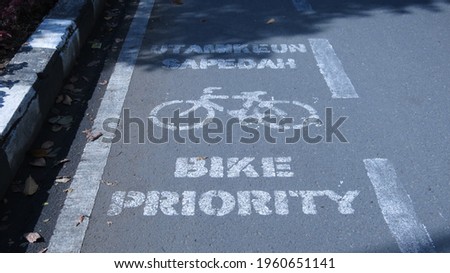 Bike priority lane sign on asphalt road in Bandung