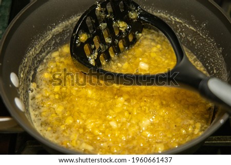 View of process of making loquat jam. sauce pan with loquat jam and potato smasher. Royalty-Free Stock Photo #1960661437