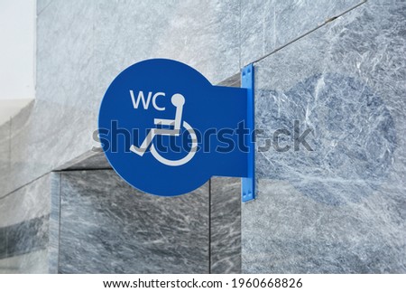 Bathroom or water closet or WC sign for handicapped wheelchair accessible restroom or toilet on Stone Wall