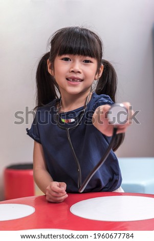 Portrait of Children, Asia girl play role as doctor with holding with toy stethoscope